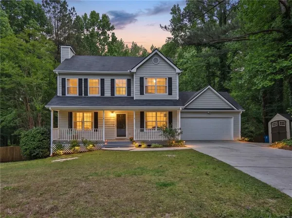 a front view of a house with a yard and trees