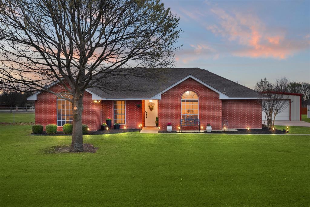 a large house with a big yard and large trees