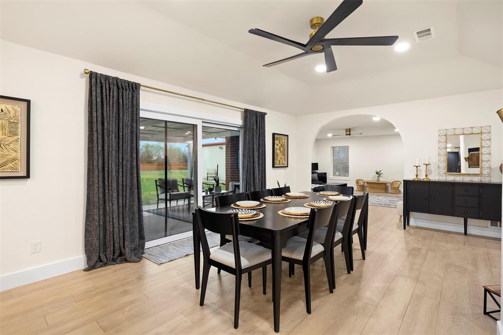 1121 Pierce Road Red Oak, TX 75154 - Photo 16 of 40 a view of a dining room and livingroom with furniture wooden floor a rug a flat screen tv