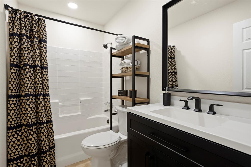 1121 Pierce Road Red Oak, TX 75154 - Photo 28 of 40 a bathroom with a sink a toilet a shower and a mirror