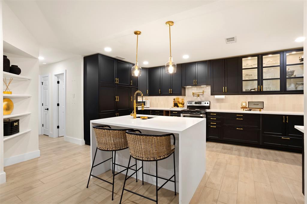 1121 Pierce Road Red Oak, TX 75154 - Photo 10 of 40 a kitchen with a refrigerator a sink dishwasher a stove and a dining table with wooden floor