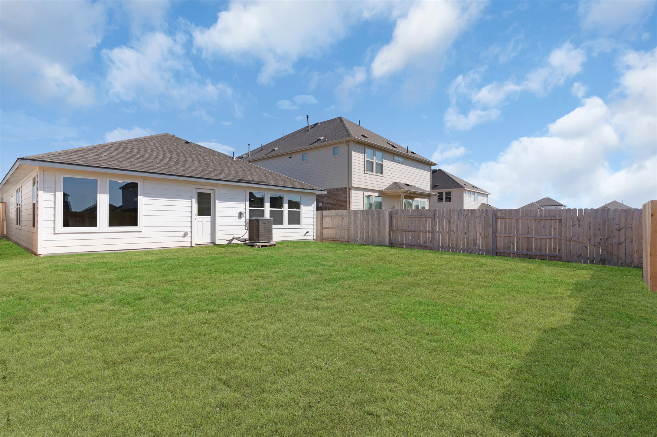 25608 Wheat Seed Lane Elgin, TX 78621 - Photo 7 of 20 Rear view of house with a fenced backyard and roof with shingles