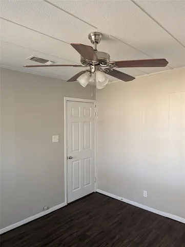 a view of a small space with wooden floor and a ceiling fan