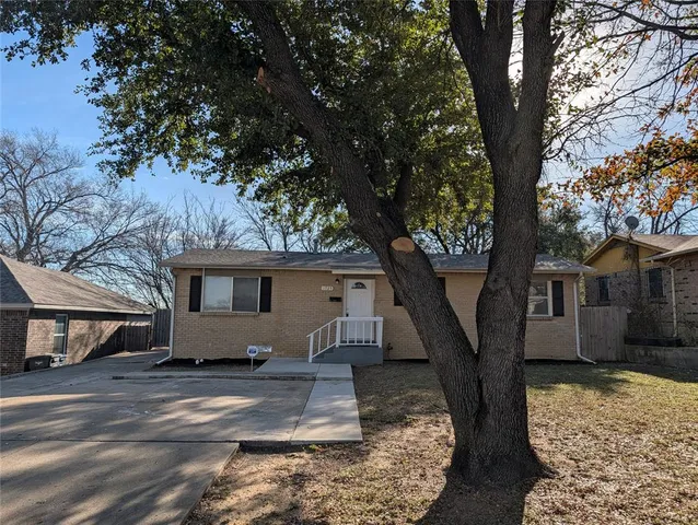 a view of a house with a large tree