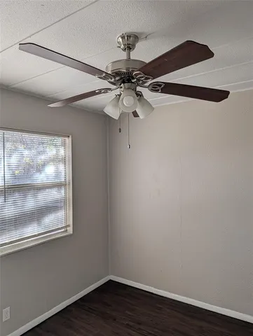 a view of a small space with wooden floor and windows