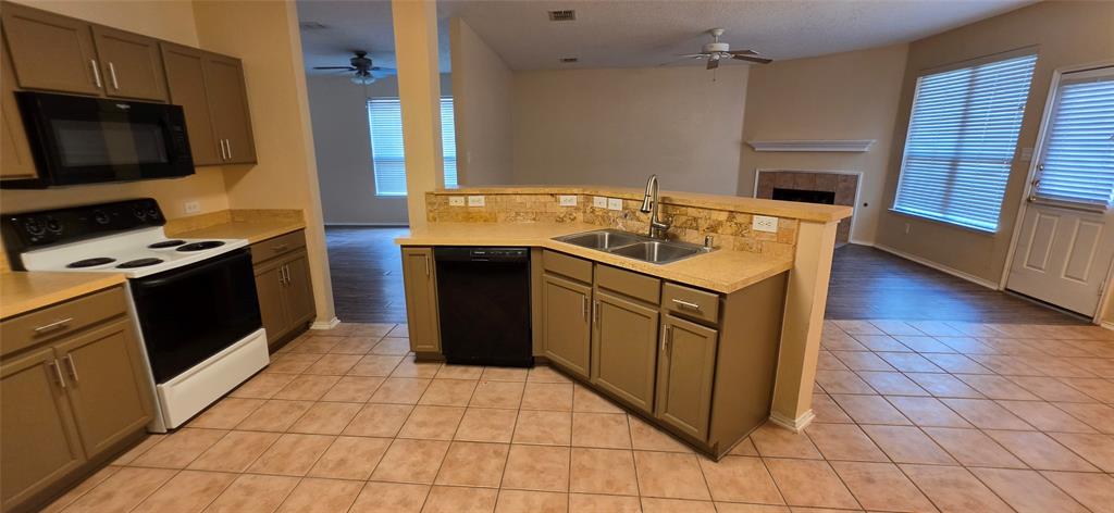 2820 Deer Ridge Drive Rockwall, TX 75032 - Photo 15 of 36 Kitchen featuring tile flooring, a dual basin sink, integrated dishwasher, and built-in microwave
