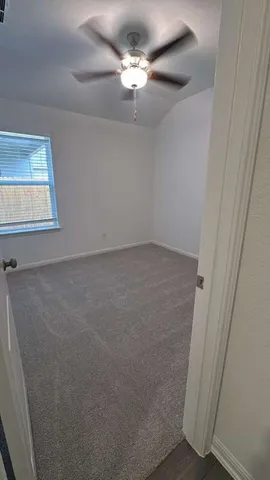 en empty room with windows and fan