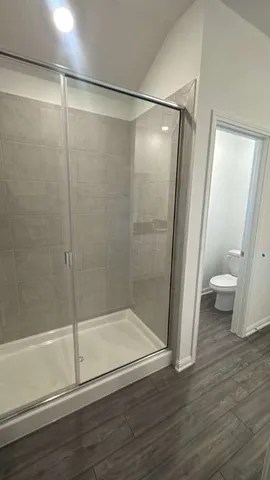 a view of empty room with wooden floor and window