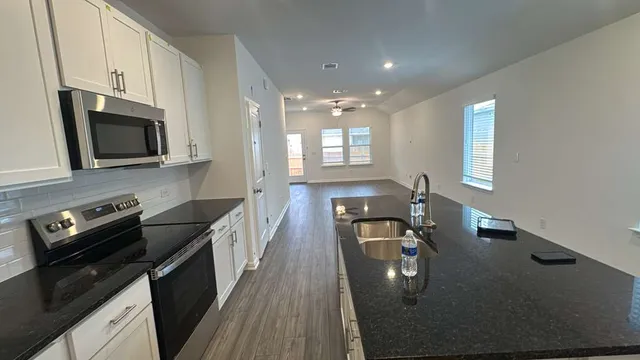 a kitchen with stainless steel appliances a stove sink microwave and cabinets