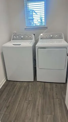 a utility room with wooden floor washer and dryer
