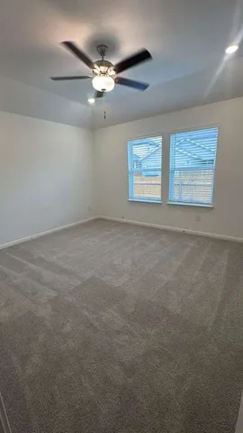 en empty room with windows and chandelier fan