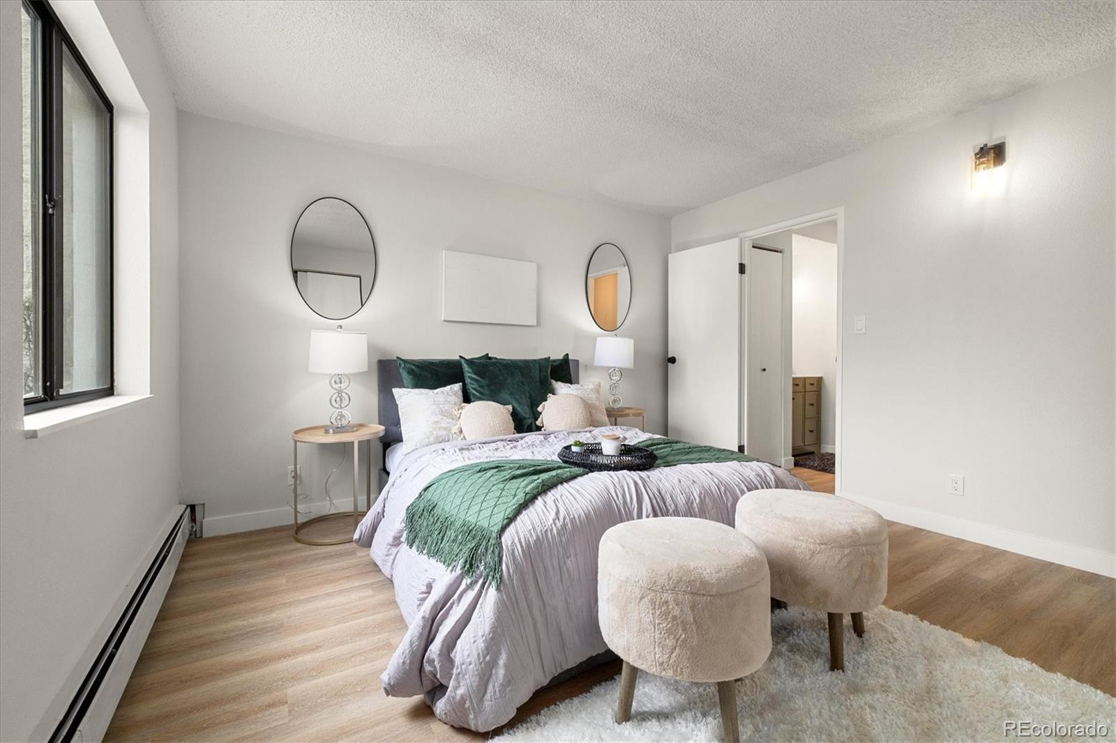 7770 West 38th Avenue, Unit 108 Wheat Ridge, CO 80033 - Photo 3 of 6 a bedroom with a bed and wooden floor