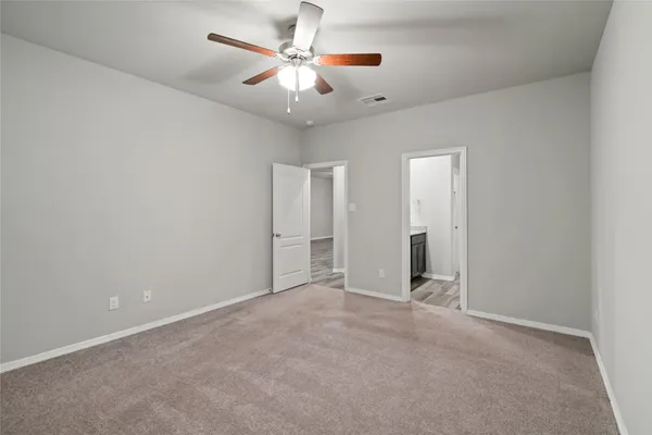an empty room with closet and a ceiling fan