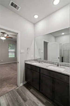 a bathroom with double sink and a mirror