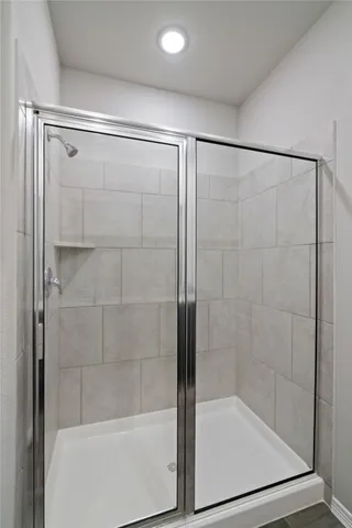 a bathroom with a shower and a glass door