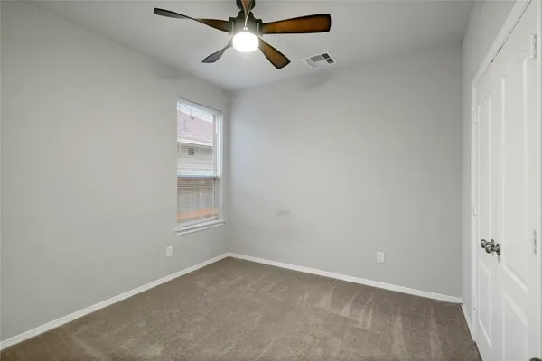 an empty room with windows and fan