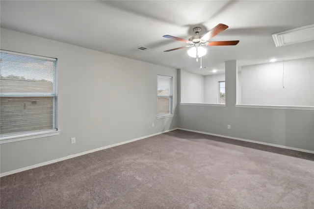 an empty room with fan and entrance