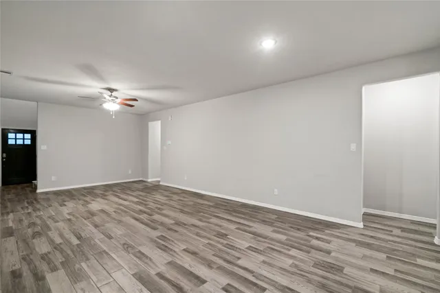 a view of empty room with wooden floor