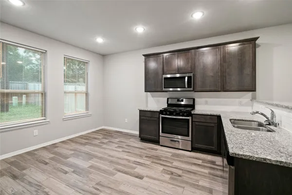 a kitchen with granite countertop a stove and a sink