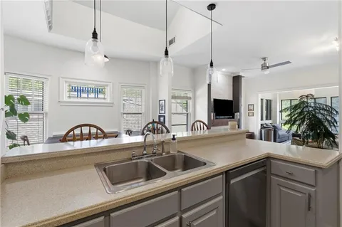 a kitchen with a sink a counter space and wooden floor