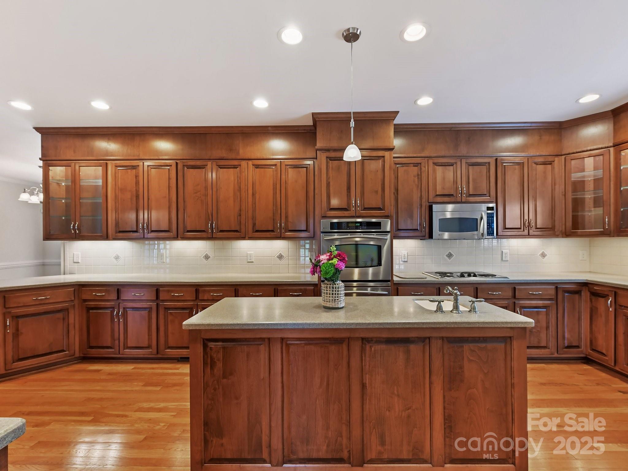 1902 Windmere Drive Monroe, NC 28110 - Photo 13 of 47 a kitchen with kitchen island granite countertop a sink cabinets and wooden floor