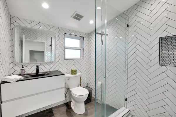 a bathroom with a toilet sink double vanity and mirror