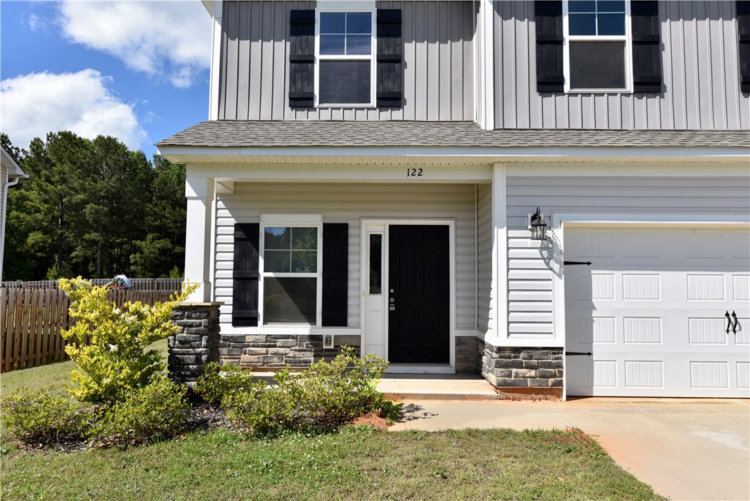 This charming home offers a welcoming facade with classic architectural elements and convenient garage access.