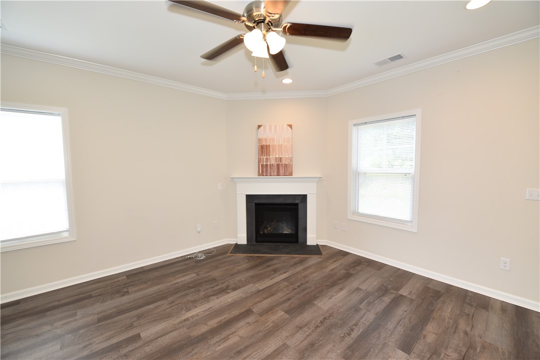 122 Bellflower Lane Anderson, SC 29625 - Photo 16 of 32 This inviting space features a corner fireplace, elegant crown molding, and durable flooring.