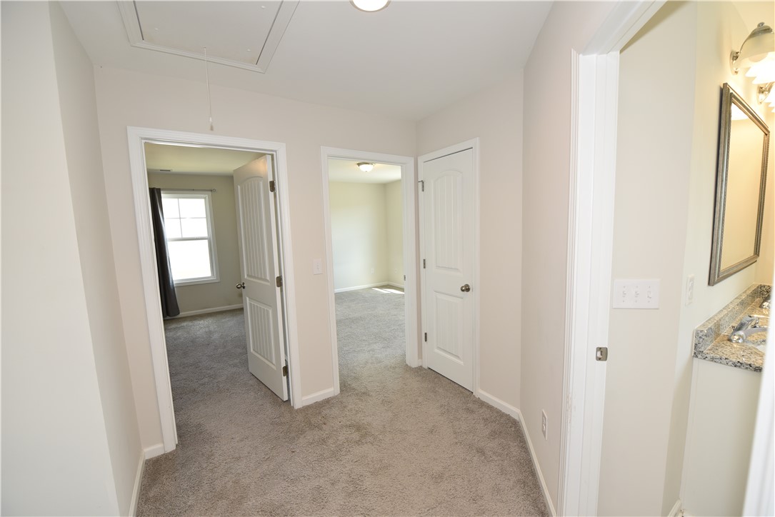 122 Bellflower Lane Anderson, SC 29625 - Photo 17 of 32 This spacious hallway connects bright rooms, featuring plush carpeting and a convenient attic access panel.