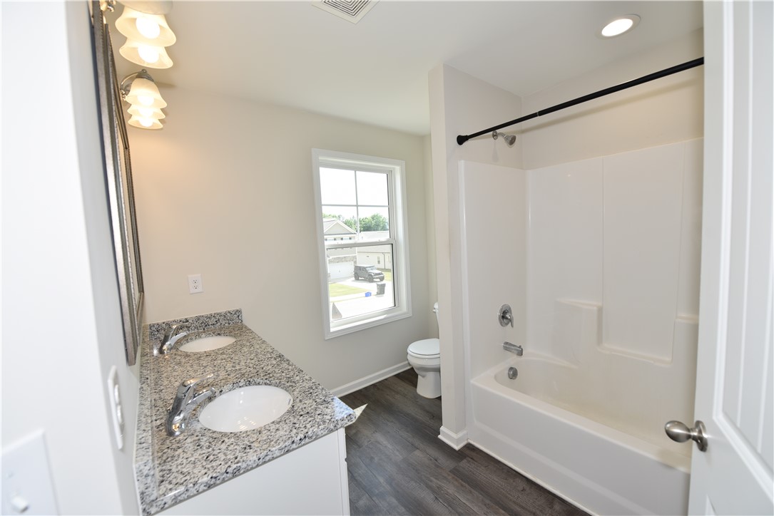 122 Bellflower Lane Anderson, SC 29625 - Photo 18 of 32 This bright bathroom features dual sinks and a shower-tub combination, providing comfort and convenience.