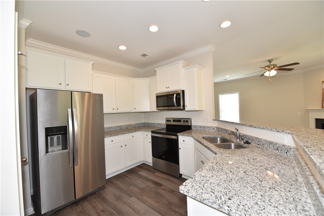122 Bellflower Lane Anderson, SC 29625 - Photo 8 of 32 This contemporary kitchen features bright cabinetry, modern appliances, and durable countertops.