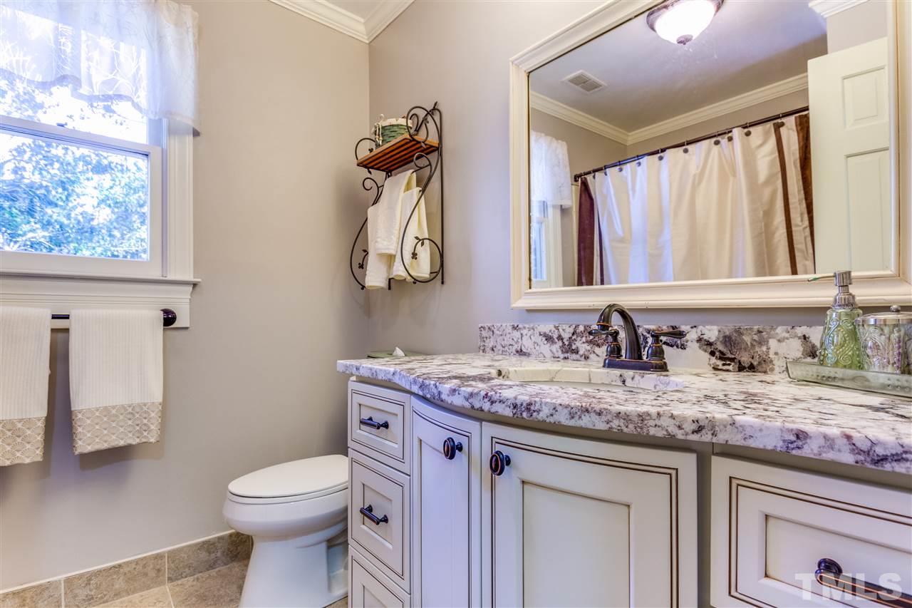 620 Downpatrick Lane Raleigh, NC 27615 - Photo 17 of 23 a bathroom with a granite countertop sink a toilet and a mirror