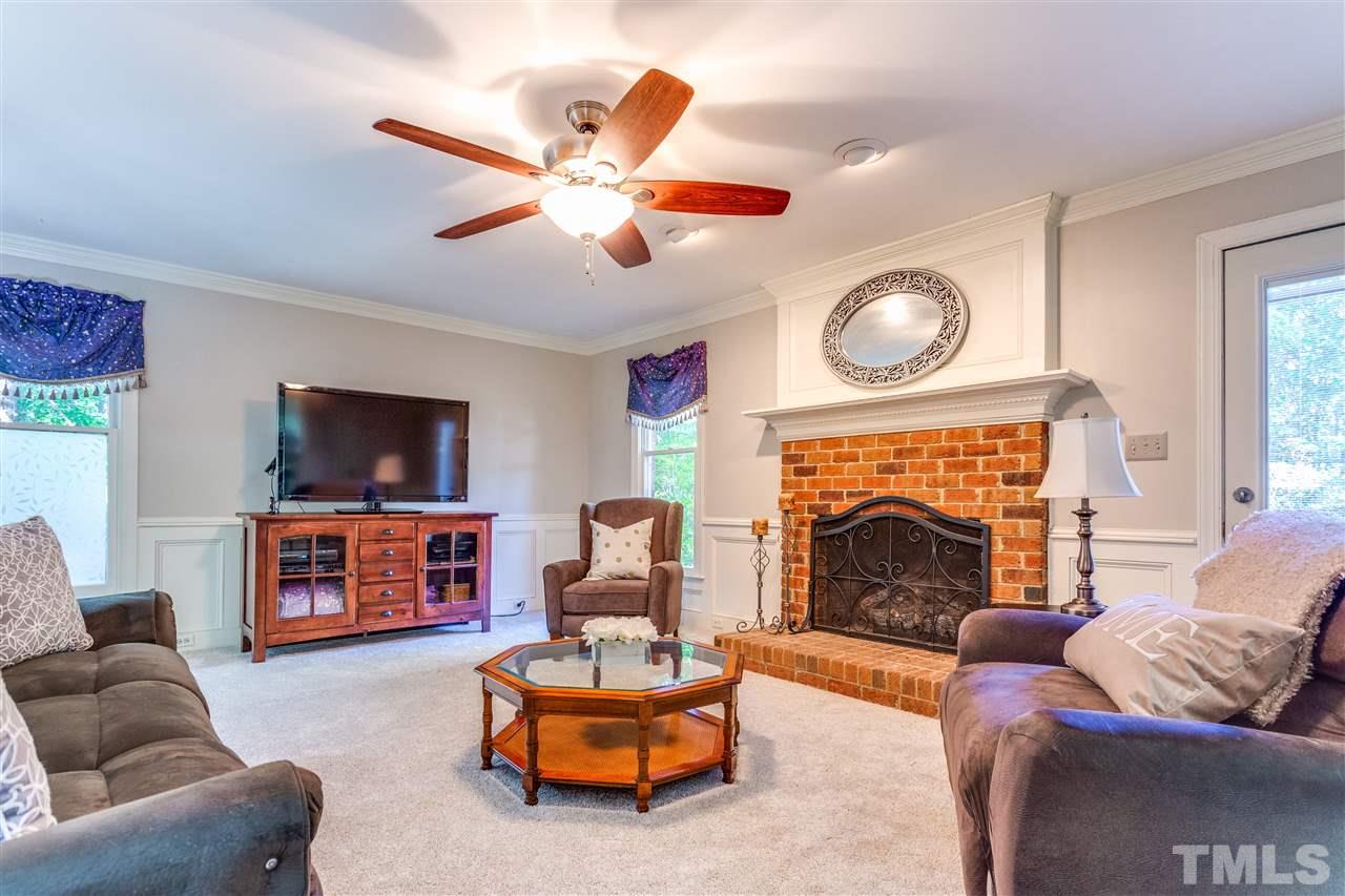 620 Downpatrick Lane Raleigh, NC 27615 - Photo 8 of 23 a living room with furniture a flat screen tv and a fireplace