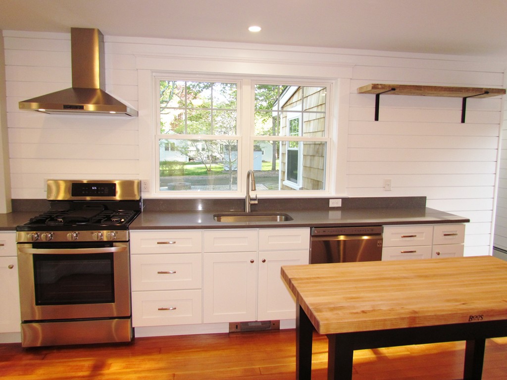 185 First Parish Road Scituate, MA 02066 - Photo 10 of 28 a kitchen with a stove a sink and a wooden cabinets