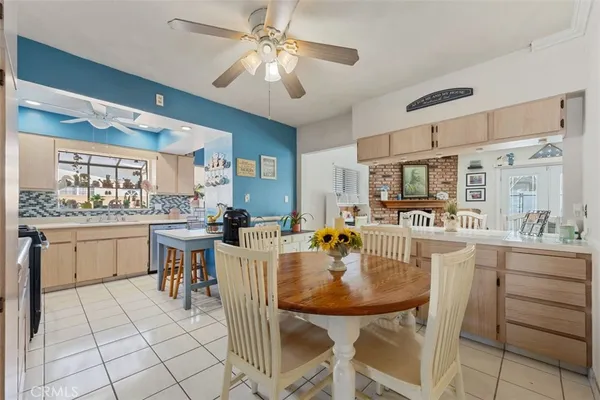 a kitchen with a dining table chairs cabinets and stainless steel appliances