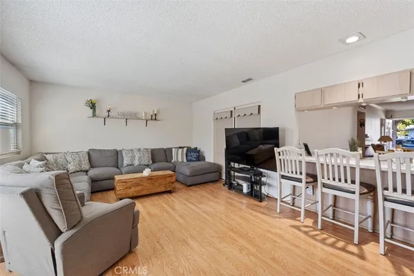 a living room with furniture a flat screen tv and a table