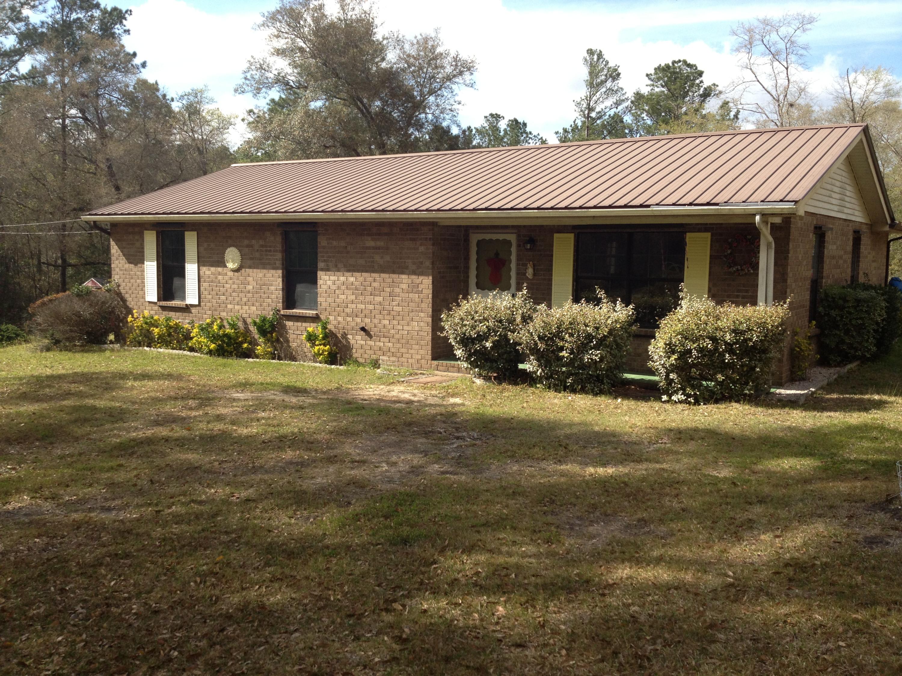 4217 Poverty Creek Road Crestview, FL 32539 - Photo 1 of 8 a front view of a house with a garden and porch