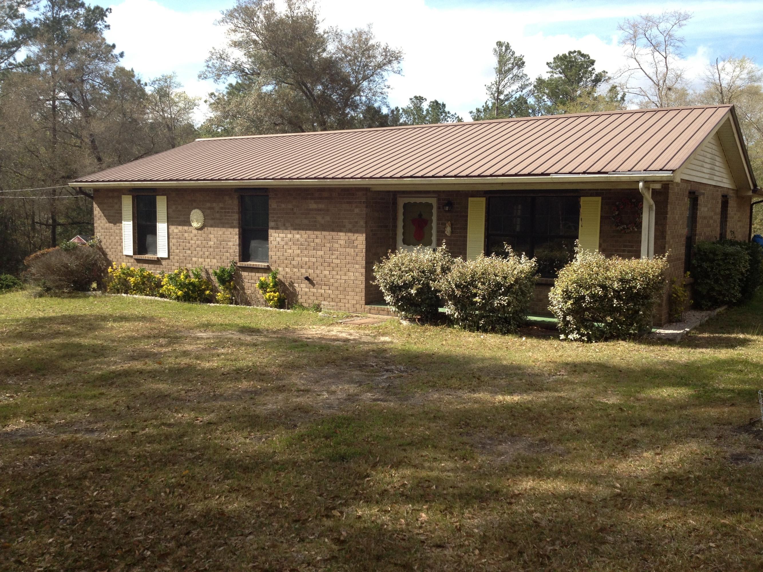 4217 Poverty Creek Road Crestview, FL 32539 - Photo 6 of 8 a front view of a house with a garden and porch
