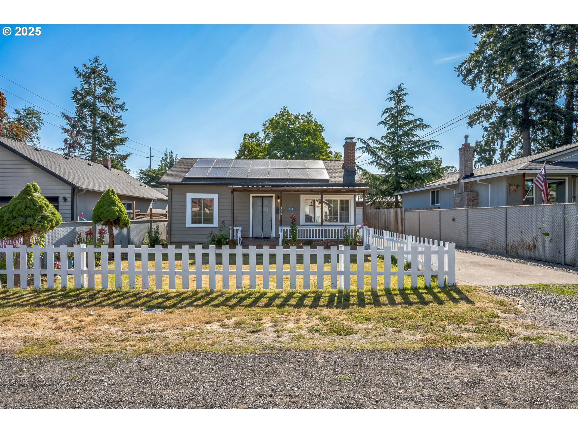 a view of a house with a small yard and wooden fence