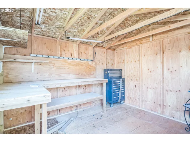 a view of an empty room with window and hardwood floor