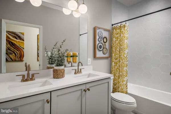 a bathroom with a sink a mirror a toilet and a shower
