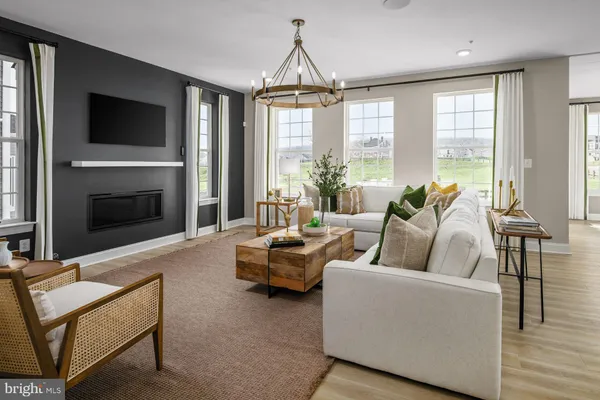 a living room with furniture fireplace and large windows