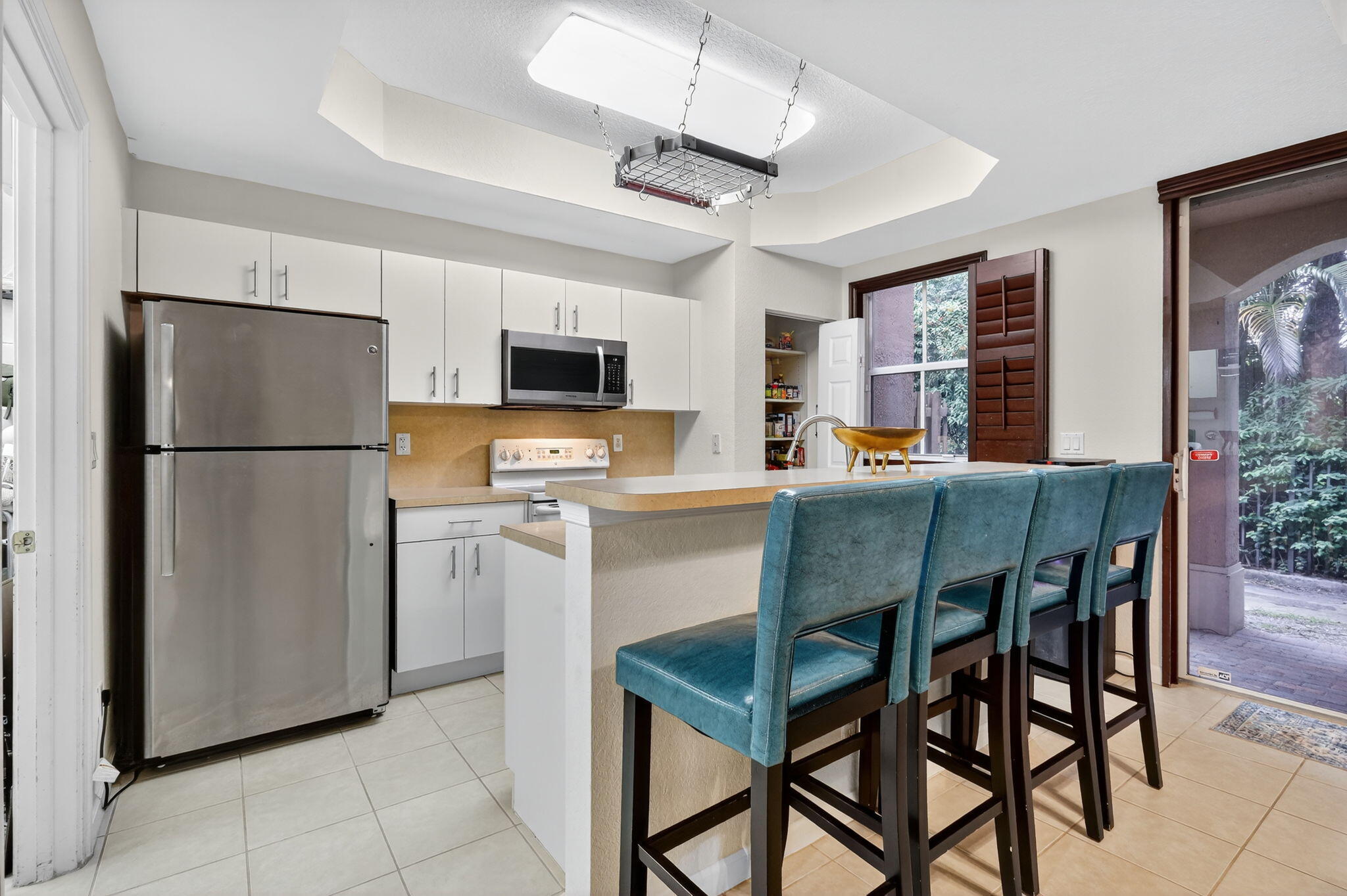 2931 Hope Valley Street, Unit 405 West Palm Beach, FL 33411 - Photo 11 of 35 a kitchen with stainless steel appliances a refrigerator a stove a microwave oven a refrigerator with a dining table and chairs