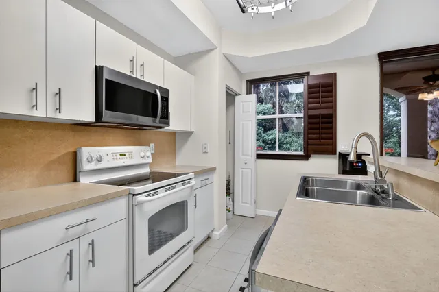 a kitchen with granite countertop a sink dishwasher stove and microwave with wooden floor