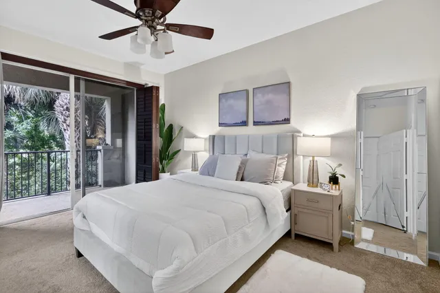 a bedroom with a large bed and a chandelier fan