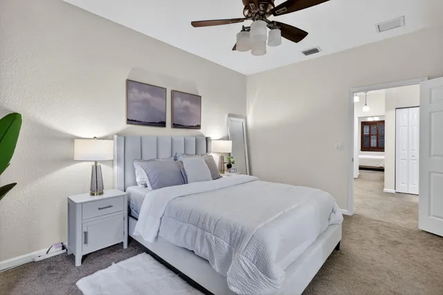 a bedroom with a large bed and a chandelier