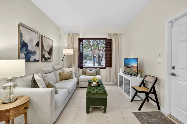 a living room with furniture a large window and a flat screen tv