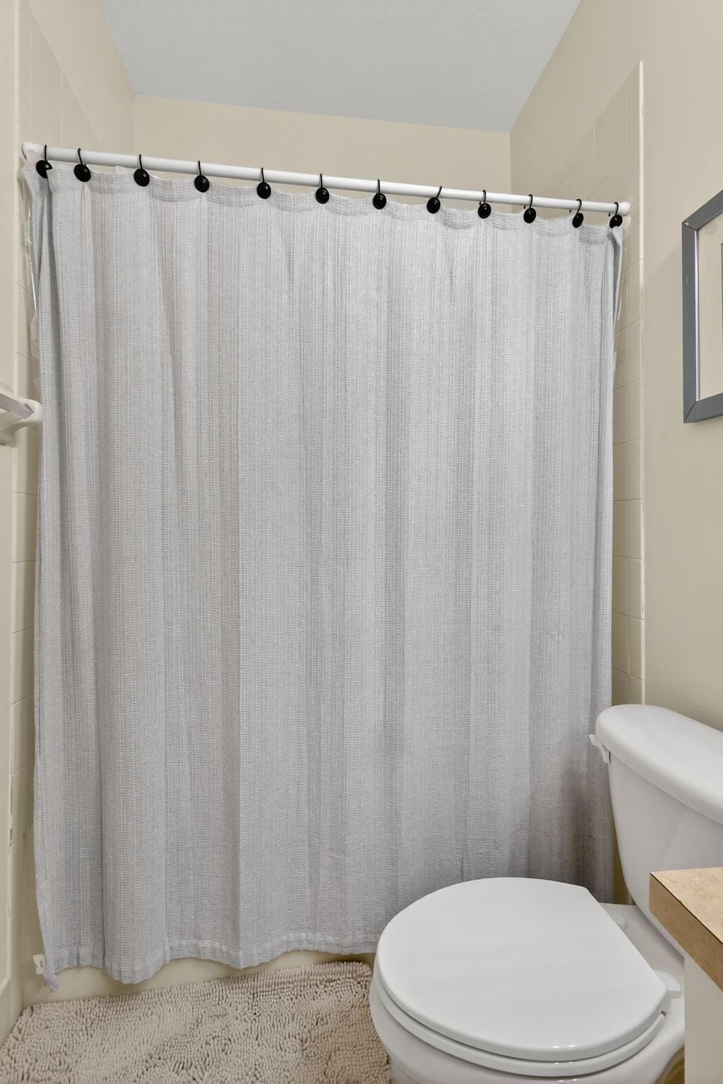 2931 Hope Valley Street, Unit 405 West Palm Beach, FL 33411 - Photo 34 of 35 a white toilet sitting next to a shower curtain