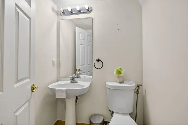 a bathroom with a sink a toilet and a mirror