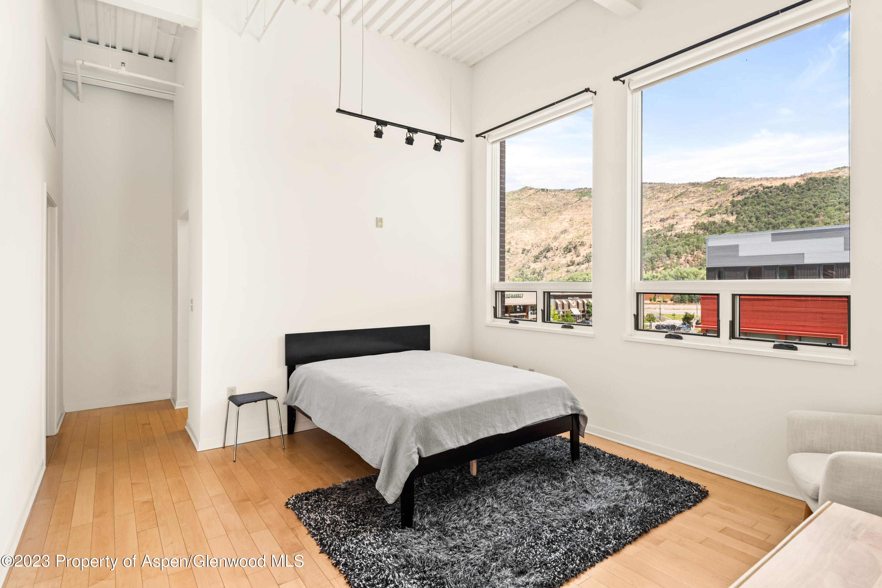 361 Robinson Street, Unit 326 Basalt, CO 81621 - Photo 4 of 10 a bedroom with a bed lamps and a large window